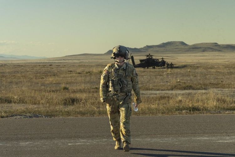 Army National Guard Soldier walking near a helicopter after training